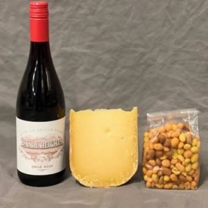 Geschenk met een fles rode wijn borrelnootjes en een stukje oude kaas
